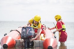 Zwei Rettungsschwimmer im Einsatz am Boot.