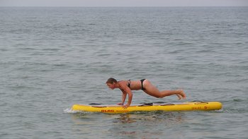 Schwimmerin im Meer auf Rettungsbrett.