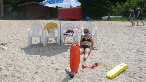 Rettungsschwimmerin sitzt am Strand in der Sonne.