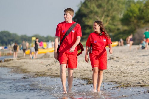 Ein Junge und ein Mädchen sind als Wachgänger am Strand unterwegs