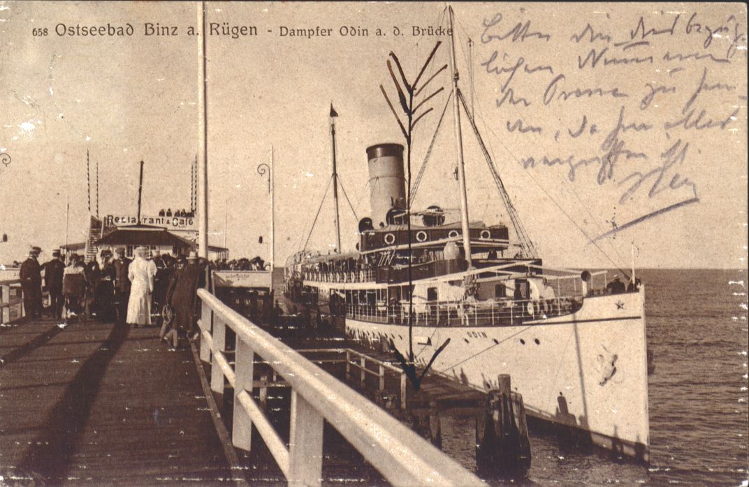 Bild einer Postkarte mit dem Motiv der Seebrücke in Binz mit einem Schiff.